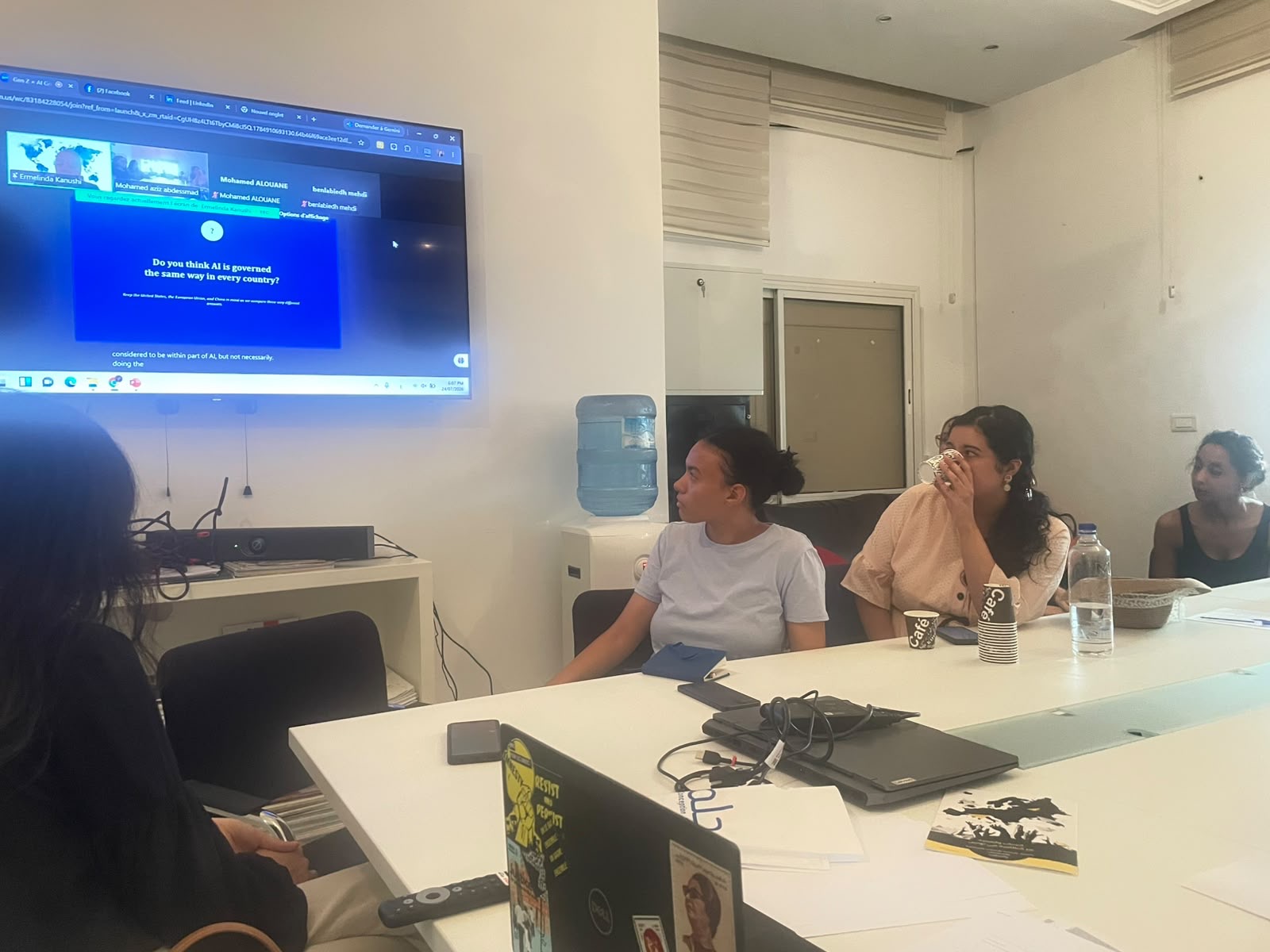 Participants watch a session slide asking whether AI is governed the same way in the United States, the European Union, and China